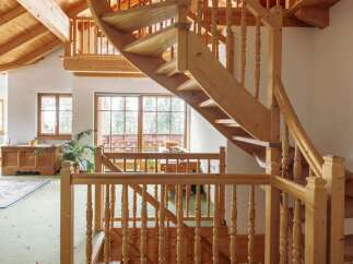 This stunning property boasts a unique, curved wooden staircase that is both functional and aesthetically pleasing.