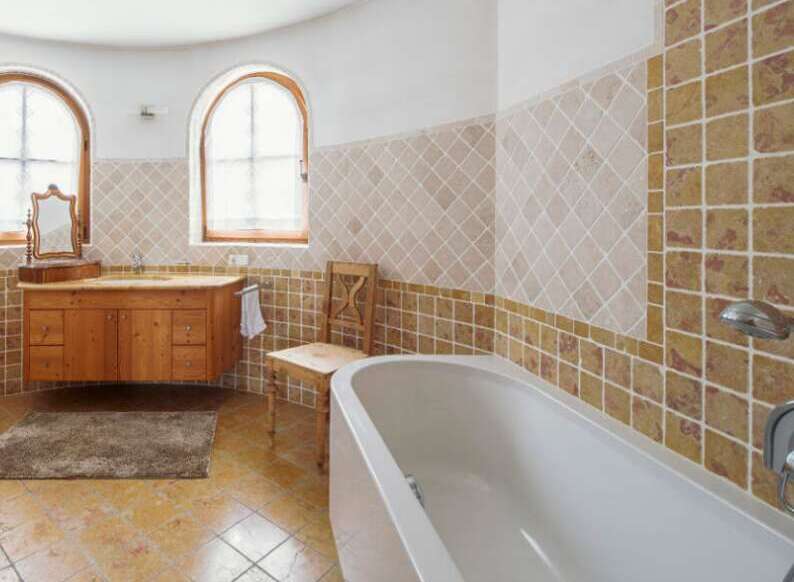 This luxurious bathroom boasts a stunning design with beige and brown tiles, creating a warm and inviting atmosphere.