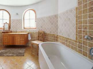 This luxurious bathroom boasts a stunning design with beige and brown tiles, creating a warm and inviting atmosphere.