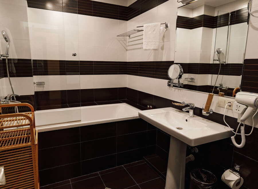 This bathroom features a modern design with a sleek white sink and toilet.