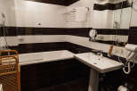 This bathroom features a modern design with a sleek white sink and toilet.