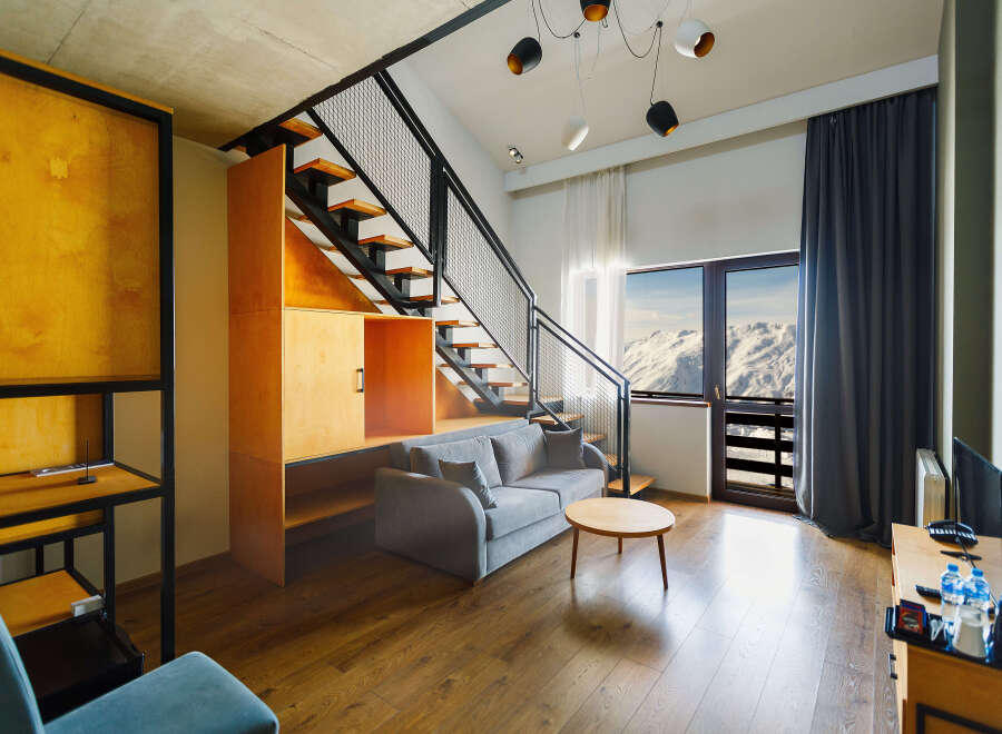 Experience modern living in this stylish apartment featuring a unique staircase design and contemporary furnishings.