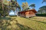 This charming lakeside log cabin offers a tranquil escape in a wooded setting.