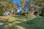 Discover this idyllic lakeside property featuring two charming wooden cabins nestled amongst mature trees.