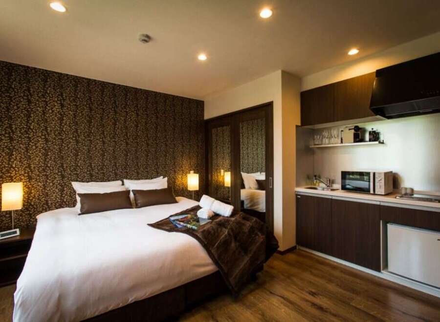 This cozy hotel room features a comfortable king-size bed, a well-equipped kitchenette with microwave and mini-fridge, and a stylish modern design.