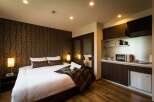 This cozy hotel room features a comfortable king-size bed, a well-equipped kitchenette with microwave and mini-fridge, and a stylish modern design.