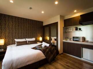 This cozy hotel room features a comfortable king-size bed, a well-equipped kitchenette with microwave and mini-fridge, and a stylish modern design.