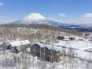 Nestled in a snowy landscape, this stunning property offers breathtaking views of a snow-capped volcano.