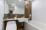 Modern bathroom with a sleek, white bathtub and toilet.