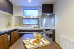 Modern kitchen with stainless steel appliances and wooden cabinetry.
