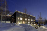 This stunning modern building is nestled in a snowy landscape, offering breathtaking views.