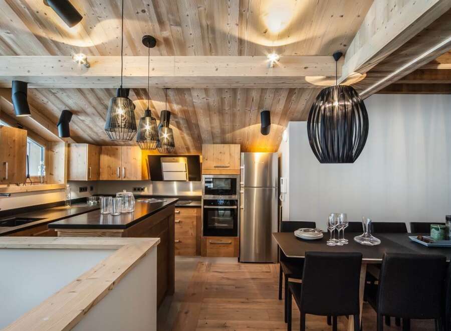This stunning chalet boasts a spacious, open-plan kitchen with high-end appliances and custom wooden cabinetry.