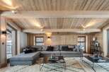 This stunning chalet boasts a spacious living area with a cozy sectional sofa, perfect for relaxing after a day on the slopes.