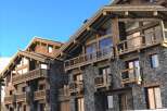 Luxury chalet apartments in the French Alps, boasting stunning mountain views and exquisite wooden architecture.