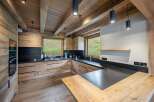 This stunning kitchen boasts a rustic-chic design with exposed wooden beams and a modern black countertop.