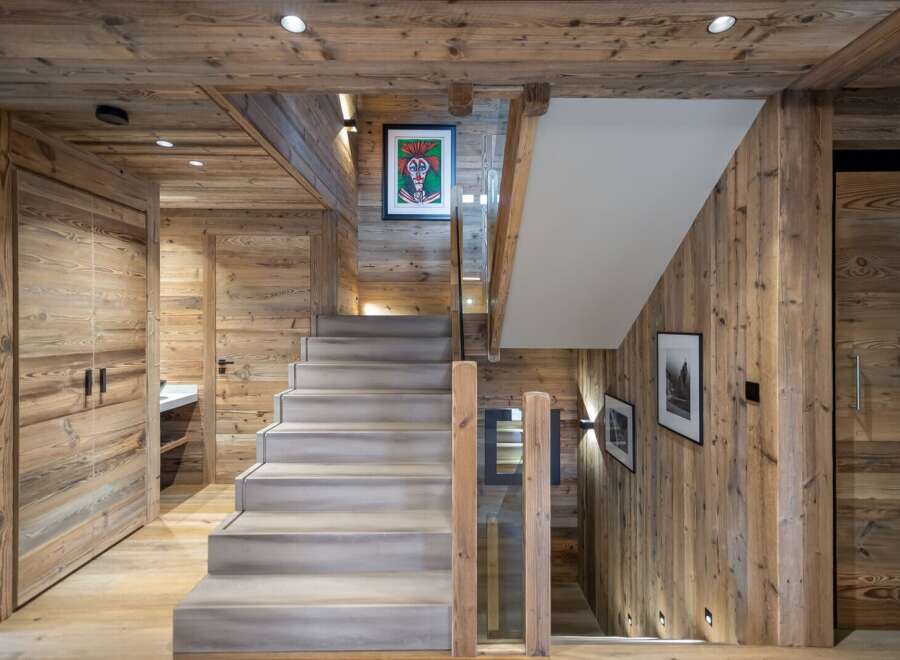 This stunning chalet boasts a grand staircase crafted from reclaimed wood, creating a rustic yet elegant ambiance.