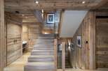 This stunning chalet boasts a grand staircase crafted from reclaimed wood, creating a rustic yet elegant ambiance.