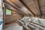 This stunning chalet boasts a spacious attic bedroom with exposed wooden beams and a cozy, rustic atmosphere.