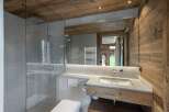 This stunning bathroom boasts a spacious walk-in shower with modern fixtures and a sleek granite countertop vanity.