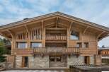 This stunning chalet boasts a beautiful wooden exterior, expansive balconies, and large windows offering breathtaking views.