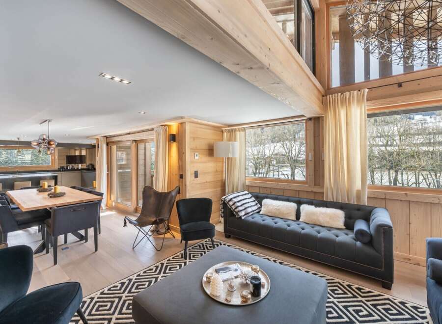 This stunning chalet boasts an open-plan living area with floor-to-ceiling windows offering breathtaking views.