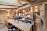 This stunning chalet boasts a spacious open-plan living area with exposed wooden beams and a cozy fireplace.