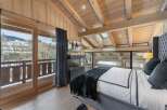 Luxurious chalet bedroom with stunning mountain views and a cozy fireplace.