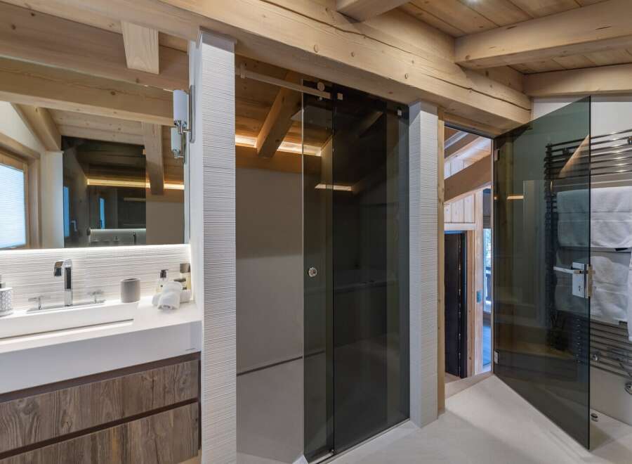 This luxurious bathroom boasts a stunning walk-in shower with a sleek, modern glass enclosure and a heated towel rack for added comfort.