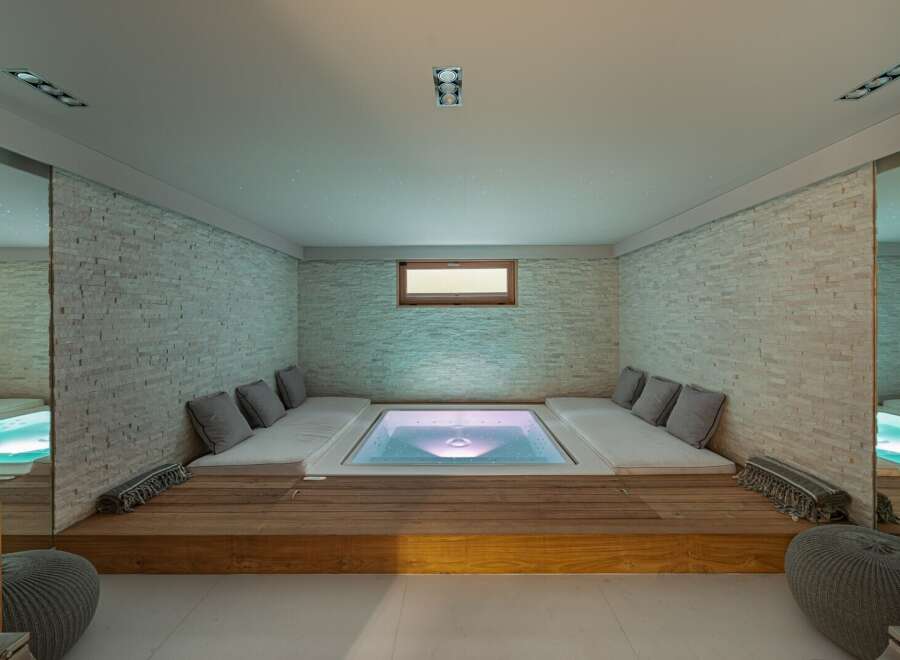 Indulge in ultimate relaxation in this stunning home spa, featuring a built-in hot tub and plush seating.