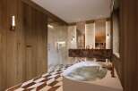Luxurious bathroom with marble and wood finishes.