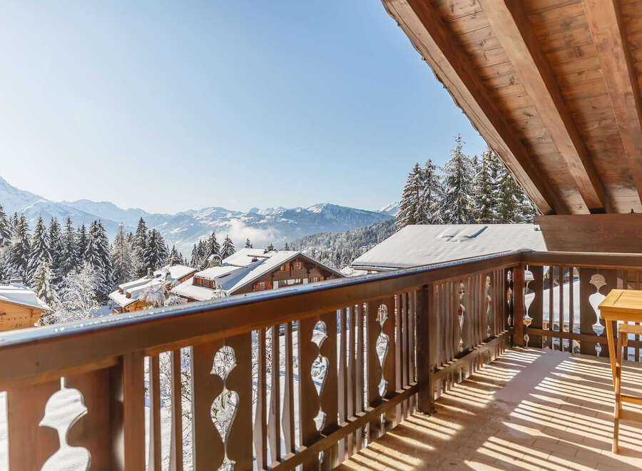 Enjoy breathtaking mountain views from this charming chalet balcony.