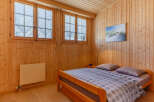 Cozy bedroom with wooden paneling and a comfortable bed.
