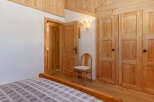 Discover the charm of this cozy bedroom, featuring warm wooden accents and a welcoming atmosphere.