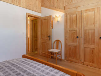 Discover the charm of this cozy bedroom, featuring warm wooden accents and a welcoming atmosphere.