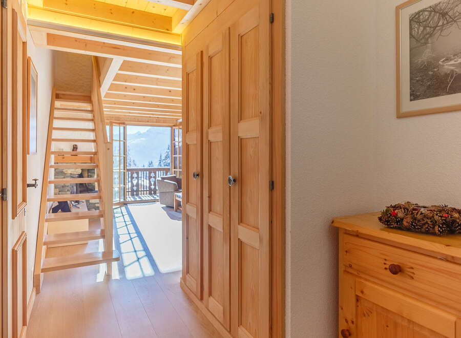 Discover the charm of this inviting home, featuring a warm wooden interior and a stunning staircase.