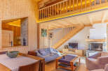 Experience the warmth of this stunning wooden cabin, featuring a cozy living area with a fireplace and a modern kitchen.