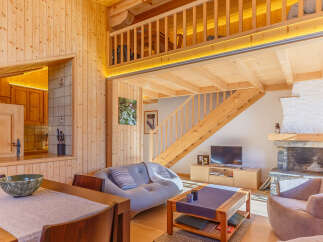 Experience the warmth of this stunning wooden cabin, featuring a cozy living area with a fireplace and a modern kitchen.