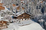 Nestled in a snowy landscape, this stunning chalet boasts a classic wooden design.