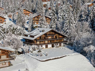 Nestled in a snowy landscape, this stunning chalet boasts a classic wooden design.