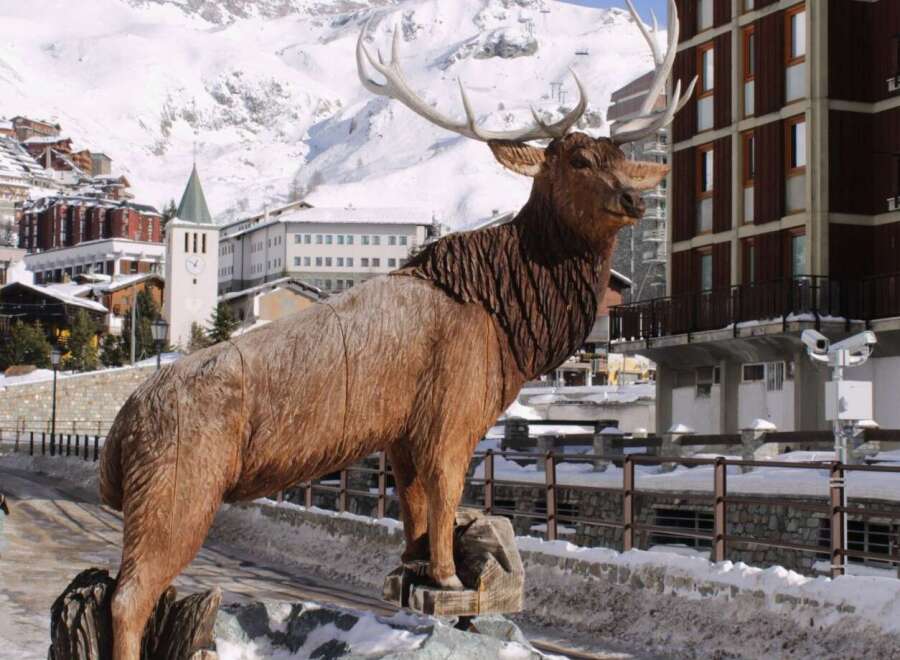 Discover the charm of this property, featuring a stunning wooden elk sculpture as a focal point.