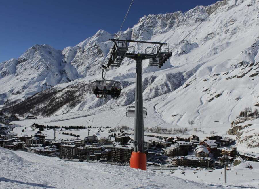 Enjoy breathtaking mountain views and a thrilling ski lift ride in this stunning winter landscape.
