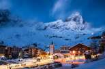 Experience the magic of a snow-covered village nestled at the foot of majestic mountains.