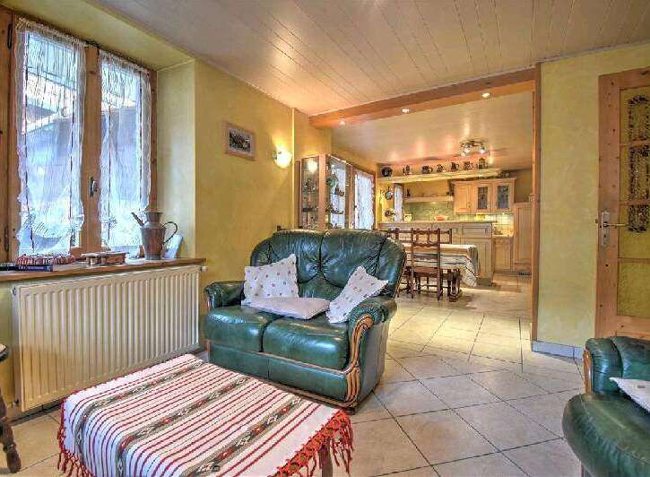 Cozy living room with a green leather sofa and a traditional-style coffee table.