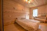 Cozy wooden bedroom with a comfortable double bed and a charming antique settee.