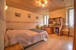 Charming bedroom with wooden ceiling and hardwood floors.