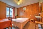 Cozy chalet room with wooden walls and a comfortable double bed.