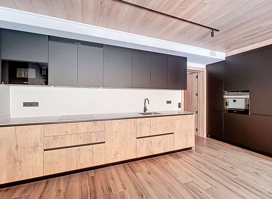 This modern kitchen boasts sleek, dark cabinetry and a stylish design.