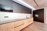 This modern kitchen boasts sleek, dark cabinetry and a minimalist design.