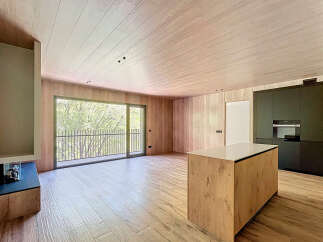 Stunning open-plan living space with large windows offering abundant natural light and views of lush greenery.