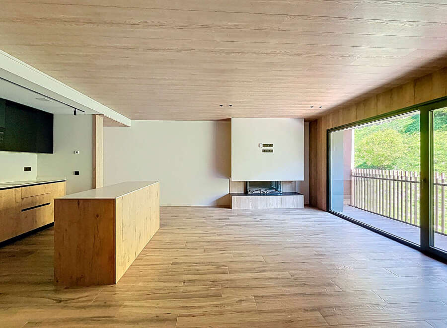 Stunning open-plan living space with a modern kitchen and built-in fireplace.